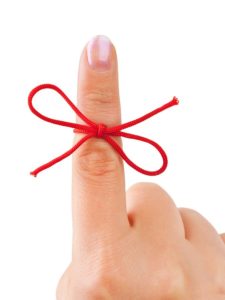 Red bow on finger isolated on white background